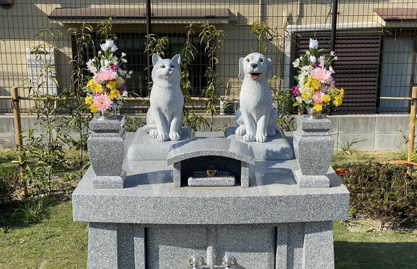 境内のペット動物供養塔。犬と猫の石像、両脇にお花