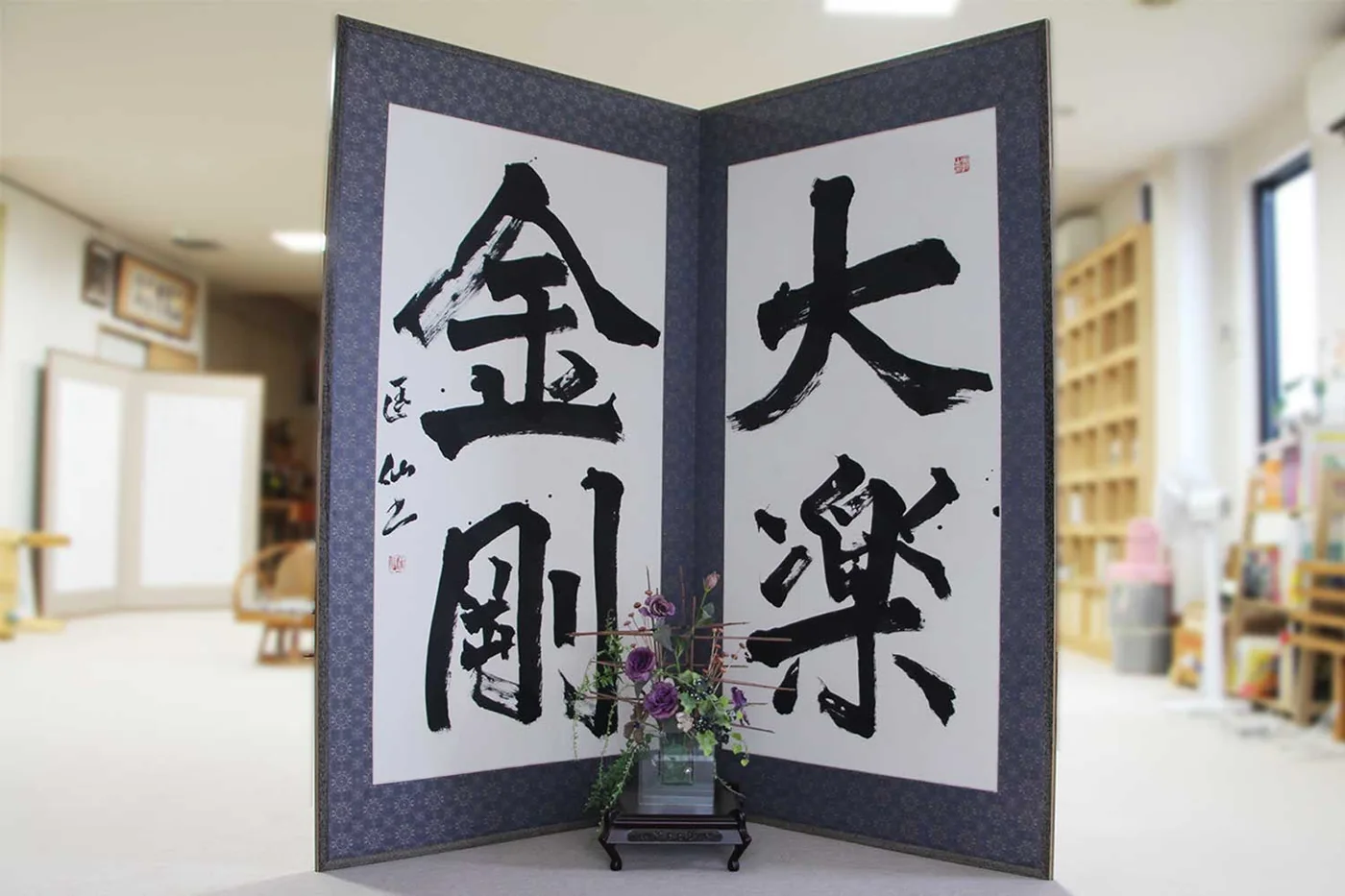 「大楽金剛」の書の屏風と生花