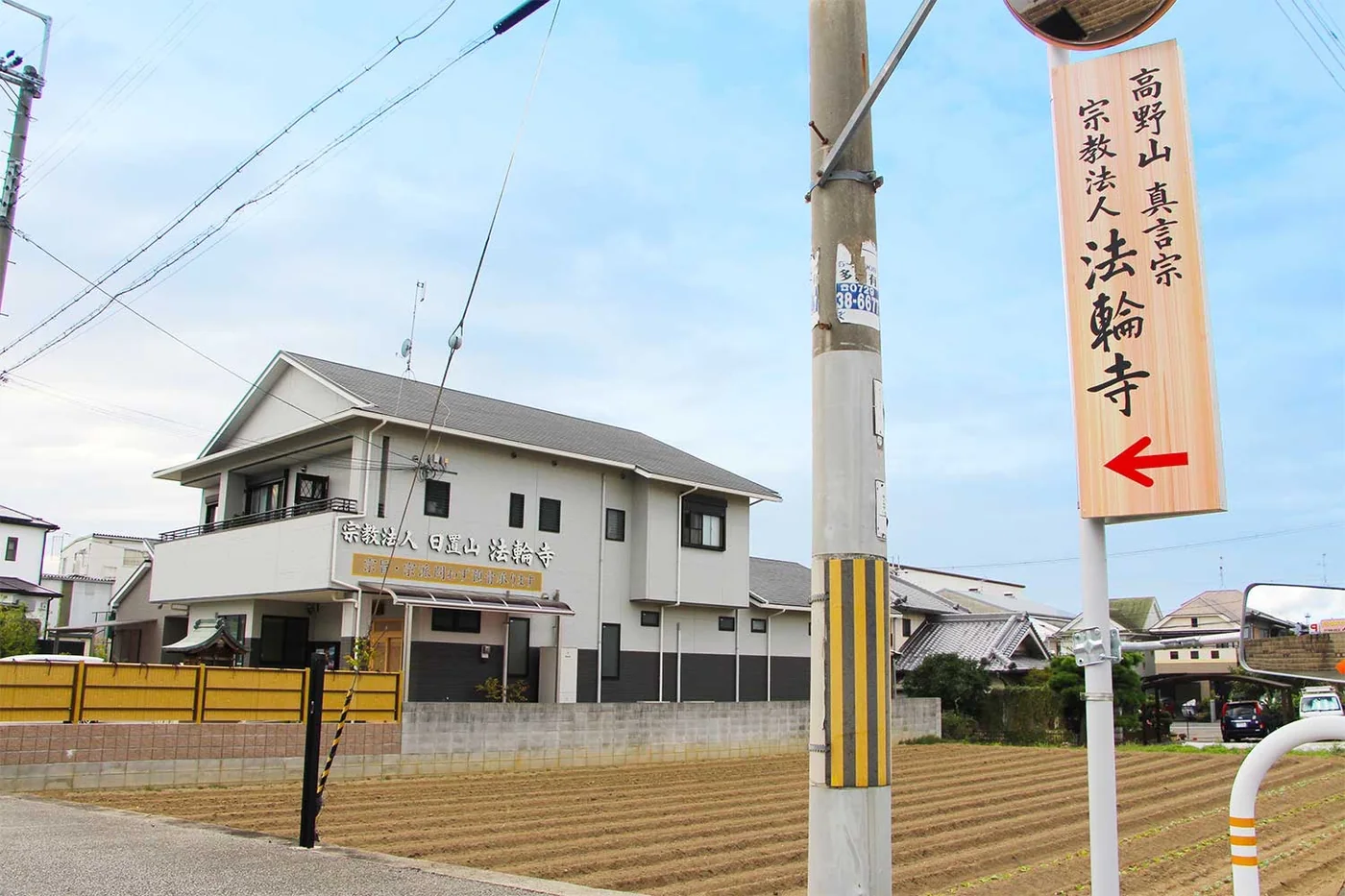 道路から見た法輪寺の外観と、「高野山真言宗 宗教法人 法輪寺」の案内看板