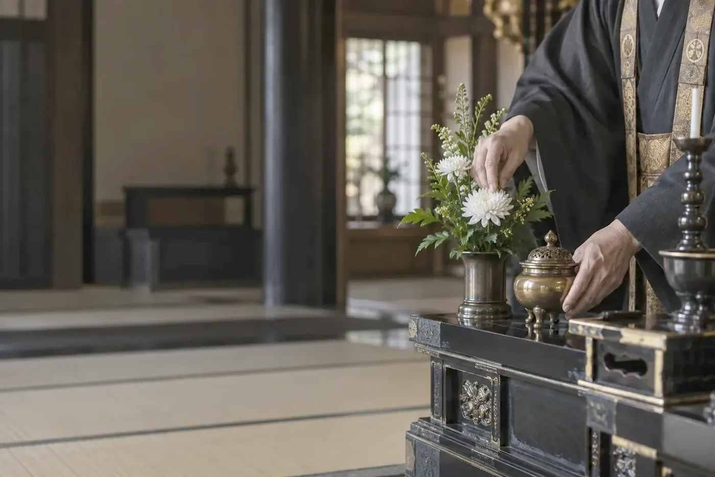 祭壇に白菊と香炉を供える僧侶