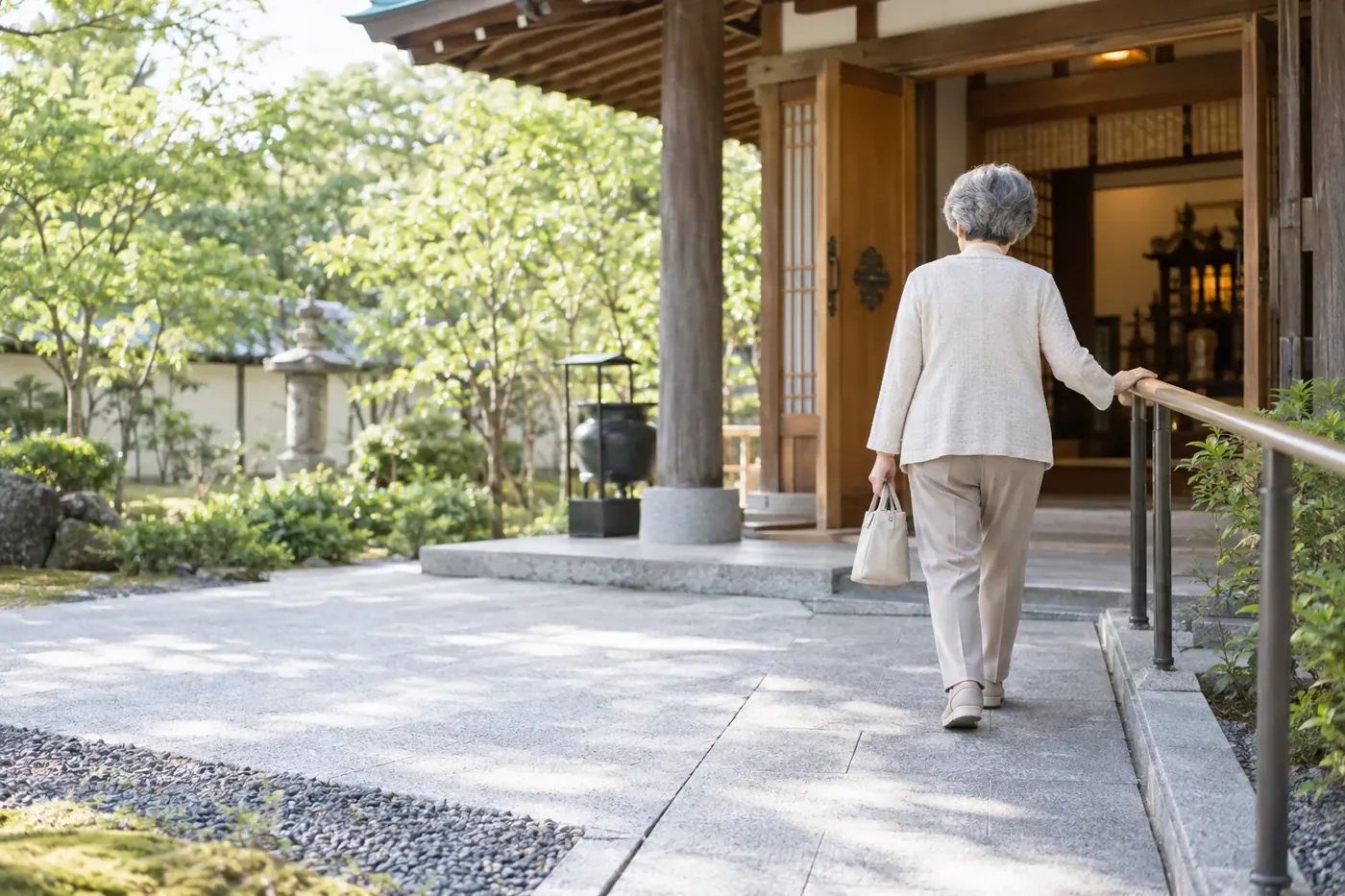 手すりにつかまって本堂へ向かう年配の方の後ろ姿