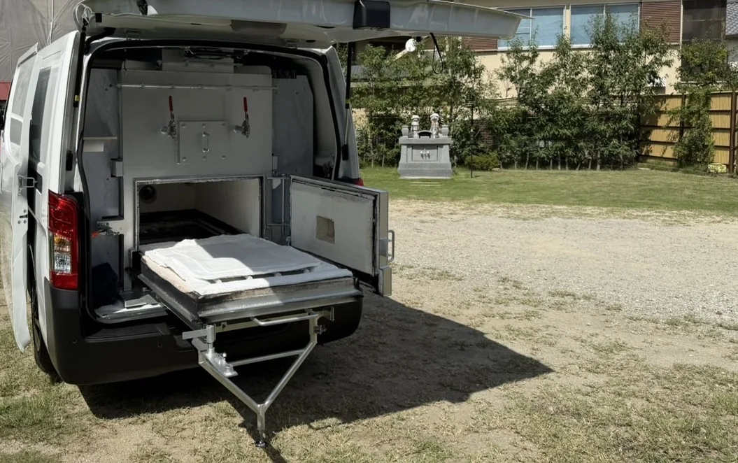 火葬車の後部扉を開けたところ。炉と、引き出した安置台